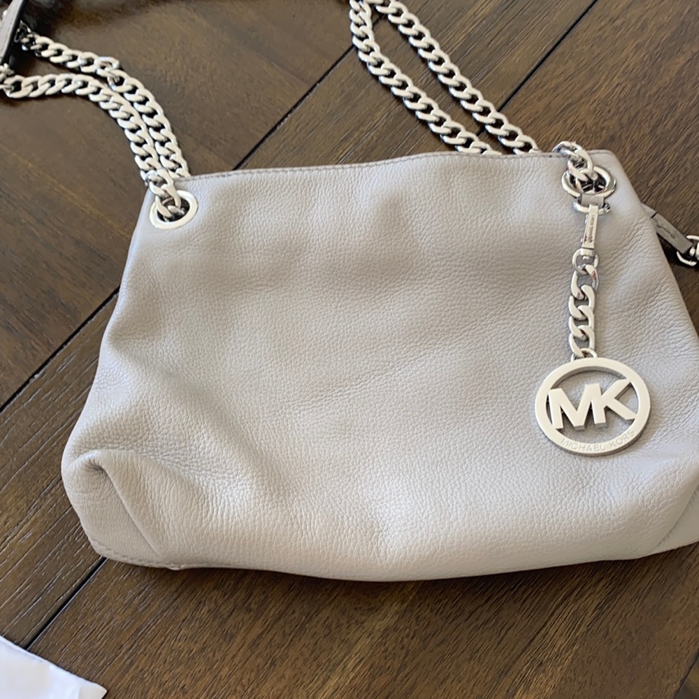 Gray leather Michael Kors purse with handbag dust cover.